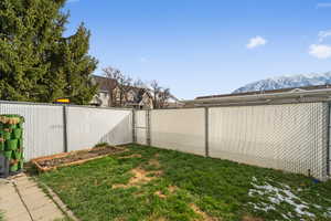 View of yard with a fenced backyard, a gate, and a mountain view