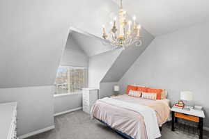 Master bedroom with baseboards, lofted ceiling, visible vents, and a chandelier