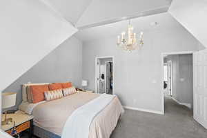 Bedroom featuring baseboards, a notable chandelier, lofted ceiling, and carpet flooring