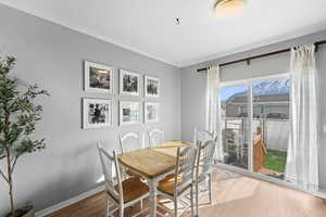 Dining space with baseboards, ornamental molding, and wood finished floors