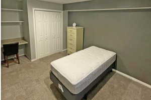 Lower level private bedroom #4 with built in desk, a closet, and carpet floors