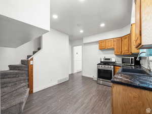 Kitchen featuring recessed lighting, stainless steel appliances, dark wood finished floors, a sink, and visible vents