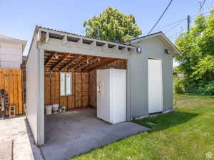 View of outbuilding with a detached carport, an outbuilding, and fence