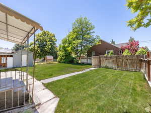 View of yard featuring a fenced backyard, an outbuilding, and a storage unit