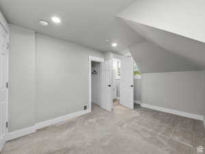 Additional living space featuring vaulted ceiling, carpet floors, baseboards, visible vents, and recessed lighting