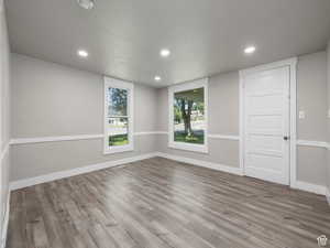 Empty room featuring baseboards, visible vents, wood finished floors, and recessed lighting