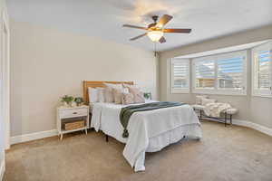 Primary Suite with baseboards, ceiling fan, and a textured ceiling