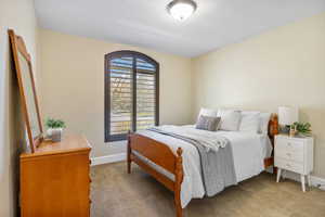 Guest Bedroom featuring light colored carpet and baseboards
