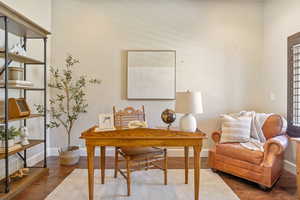 Home office with baseboards and wood finished floors