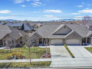 View of front of property with a residential view, driveway, a front yard, a mountain view, and a garage