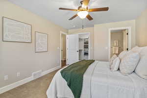 Primary Suite featuring a spacious closet, a textured ceiling, baseboards, visible vents, and ceiling fan