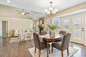 Dining space featuring hardwood / wood-style floors, lofted ceiling, visible vents, and plenty of natural light