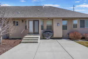 Back of house featuring stucco siding, roof with shingles, and a patio area