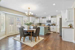 Dining room with recessed lighting, a notable chandelier, dark wood-type flooring, and a textured ceiling