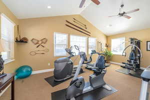 Workout room with baseboards, vaulted ceiling, recessed lighting, and a ceiling fan