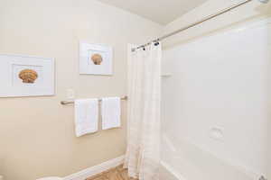 Full bathroom featuring baseboards, shower / tub combo with curtain, and tile patterned floors