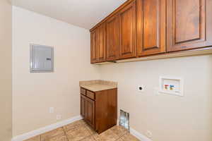 Laundry area with hookup for a gas dryer, light tile patterned floors, hookup for a washing machine, electric dryer hookup, and electric panel