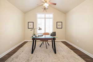Office featuring baseboards, lofted ceiling, a ceiling fan, and dark wood-style flooring