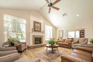 Living room featuring light wood-style flooring, visible vents, a healthy amount of sunlight, and a ceiling fan
