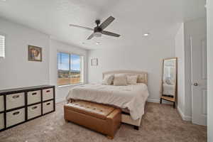 Bedroom featuring baseboards, a textured ceiling, carpet floors, and a ceiling fan