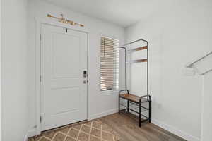 Foyer featuring baseboards and wood finished floors