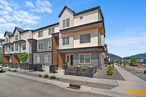 View of front of home with a residential view, a fenced front yard, and a mountain view