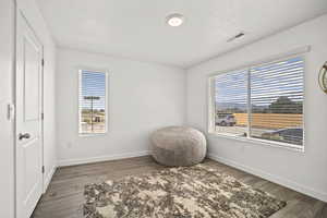 Misc room featuring baseboards, visible vents, and wood finished floors