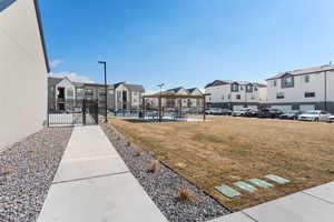 View of community featuring a residential view, fence, and a lawn