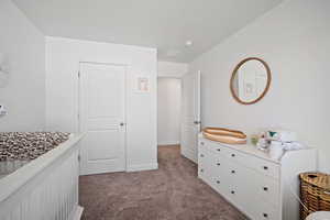 Bedroom with light colored carpet and baseboards