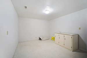Empty room featuring visible vents, baseboards, and light floors