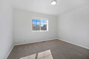 Unfurnished room featuring carpet flooring, baseboards, and visible vents