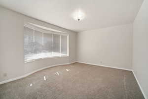 Empty room with carpet flooring and baseboards