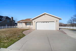 Ranch-style house featuring brick siding, fence, and concrete driveway