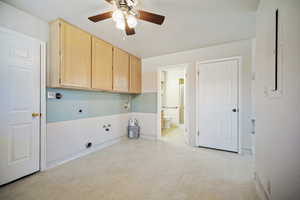 Laundry room with hookup for a washing machine, ceiling fan, light floors, electric dryer hookup, and cabinet space