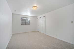 Unfurnished bedroom featuring a closet, light carpet, baseboards, and visible vents