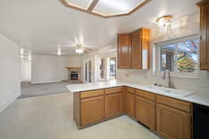 Kitchen with black dishwasher, a healthy amount of sunlight, a sink, and a peninsula