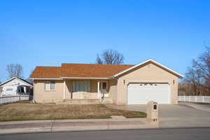 Ranch-style house featuring driveway, a garage, fence, and brick siding