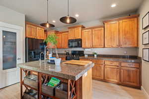 Kitchen featuring a sink, recessed lighting, black appliances, and light wood-style floors