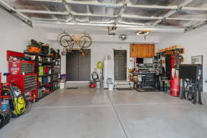 Garage with water heater, a garage door opener, and a workshop area