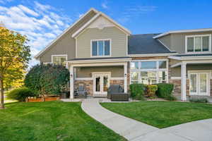 Back of property with stone siding, stucco siding, french doors, and a yard