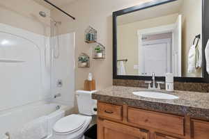 Bathroom featuring toilet, visible vents, shower / bathing tub combination, and vanity