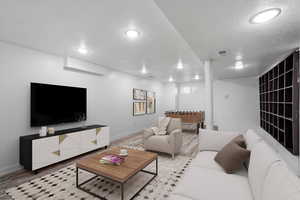 Living room featuring baseboards, a textured ceiling, visible vents, and light wood-style floors