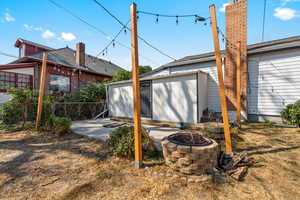Back of house featuring fence, an outdoor fire pit, and a patio area