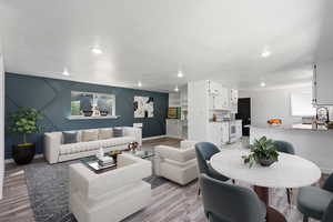 Living room featuring light wood-style flooring, baseboards, and a textured ceiling