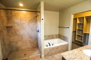 Full bath with a garden tub, vanity, a shower stall, and recessed lighting