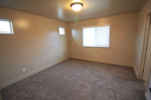 Carpeted spare room with baseboards