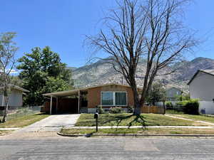 (Spring Photo) View of front of home featuring a mountain view, concrete driveway, brick siding, and a carport