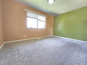 Carpeted empty room with baseboards