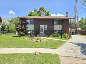 View of front of home with a chimney and brick siding