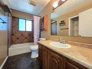 Bathroom with vanity, toilet, shower / tub combo with curtain, and baseboards